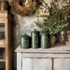 Set of vintage green canisters decorated with IOD Figgy & Flourish gold foil transfer holiday labels and motifs