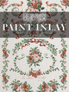 Front packaging of IOD La Folie Paint Inlay featuring floral and ribbon details