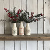 Three white vases decorated with deer, Christmas carol, and wreath designs from Twelfth Night Inlay.