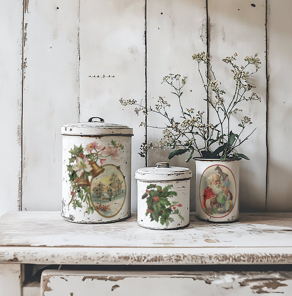 Vintage-style white canisters decorated with IOD Christmas Joy Transfer featuring Santa, holly, and winter church scene.